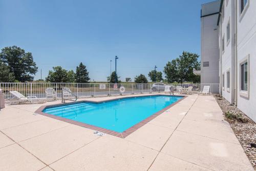 a swimming pool in a yard next to a building at Motel 6-Junction City, KS in Junction City