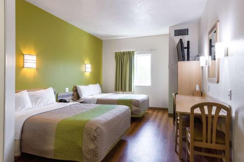 Habitación de hotel con 2 camas y mesa en Motel 6-Cedar City, UT en Cedar City