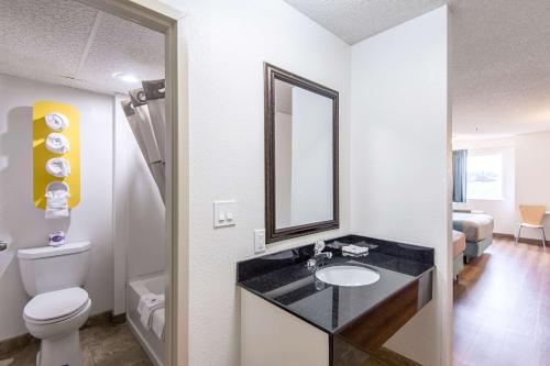 a bathroom with a sink and a toilet and a mirror at Motel 6-Lawrence, KS in Lawrence