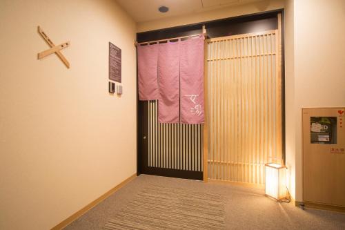 a room with a door with a towel on it at Dormy Inn Izumo in Izumo