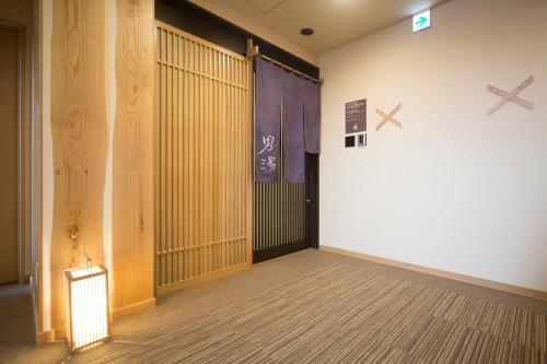 an empty room with a large door with crosses on the wall at Dormy Inn Izumo in Izumo