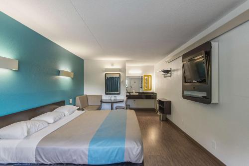 a hotel room with a large bed and a flat screen tv at Motel 6-Overland Park, KS in Overland Park