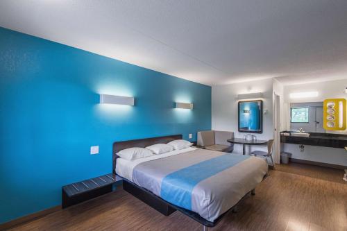 a bedroom with a large bed and a blue wall at Motel 6-Overland Park, KS in Overland Park