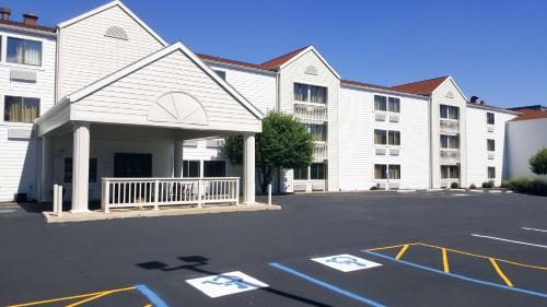 un grand bâtiment blanc avec un parking en face de celui-ci dans l'établissement Motel 6-Maryland Heights, MO, à Maryland Heights