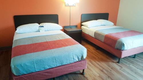 two beds in a hotel room with two bedsskirts at Motel 6-Maryland Heights, MO in Maryland Heights