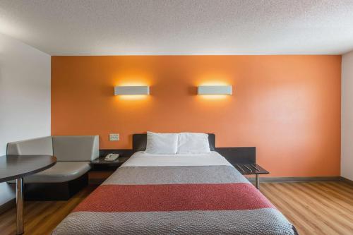 a room with a bed and a desk and a chair at Motel 6 Omaha - Central in La Vista