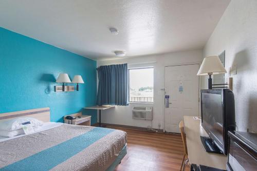 a hotel room with a bed and a television at Motel 6 Kansas City, MO - Airport in Kansas City