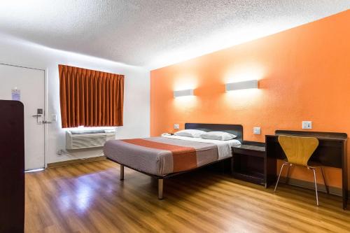 a bedroom with a bed and a desk and a chair at Motel 6-Long Beach, CA - International City in Long Beach