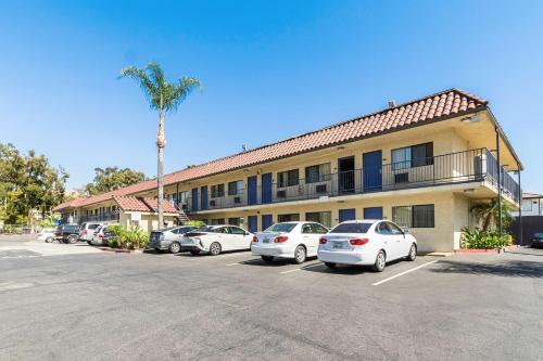 a parking lot in front of a hotel with parked cars at Motel 6 Riverside, CA - UCR East in Riverside