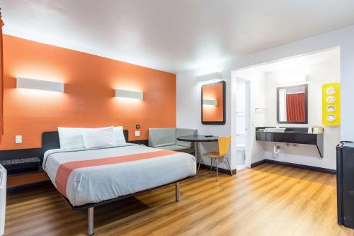 a hotel room with a bed and a desk at Motel 6 Riverside, CA - UCR East in Riverside