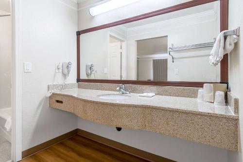 a bathroom with a sink and a large mirror at Motel 6-Kingsburg, CA in Kingsburg