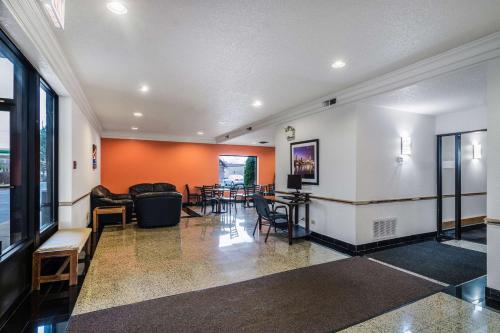 a living room with orange walls and chairs at Motel 6-Libertyville, IL in Libertyville