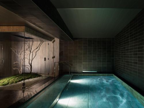 a swimming pool with a tree in the middle of a room at Kyoto Granbell Hotel in Kyoto
