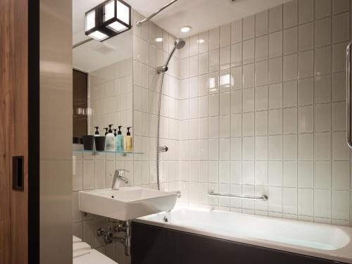 a bathroom with a sink and a bath tub at Kyoto Granbell Hotel in Kyoto