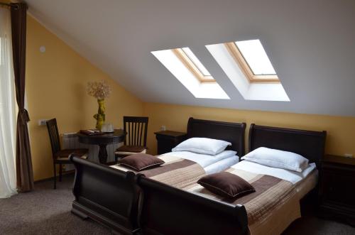two beds in a bedroom with skylights at Pensiunea Koruna in Poenari