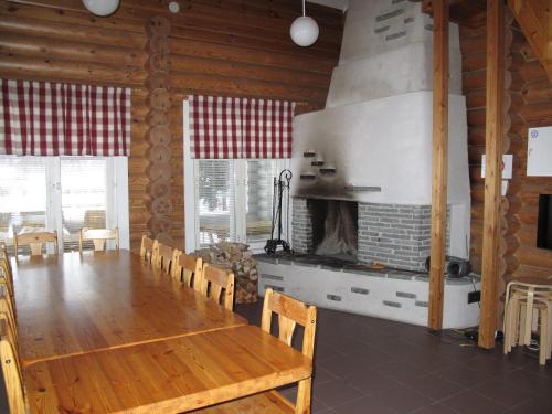 a dining room with a table and a fireplace at Marttinen in Virrat