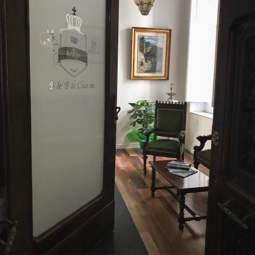 a hallway with a door with a chair and a table at Borbo de Charme in Naples