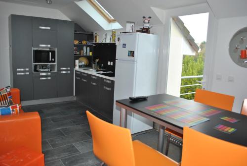 - une cuisine avec une table et des chaises orange dans l'établissement Oyats baie, à Groffliers