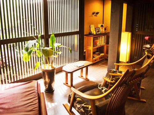 a room with two chairs and a balcony with a plant at Migiwatei Ochi Kochi in Fukuyama