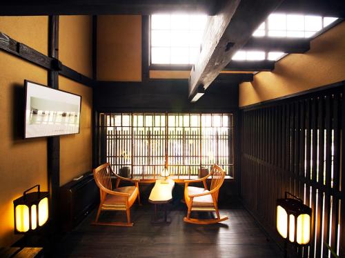 a room with chairs and a table and a window at Migiwatei Ochi Kochi in Fukuyama