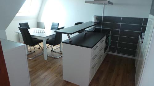 a kitchen with a desk and a table and chairs at Residence le Crisenoy in Houlgate