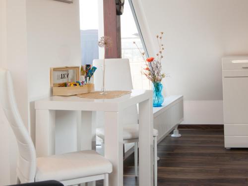 ドレスデンにあるGastezimmer Richterの窓付きの客室で、白いテーブルと椅子が備わります。