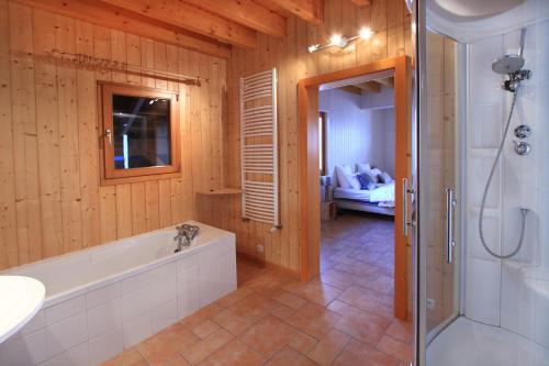 a bathroom with a tub and a sink and a shower at Chalet la roche du rain in Gérardmer