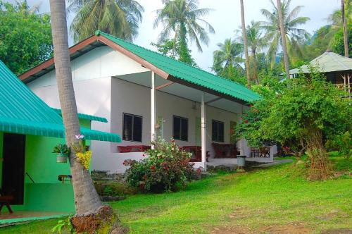 a white and green house with a green roof at TP Hut Bungalows in Ko Chang
