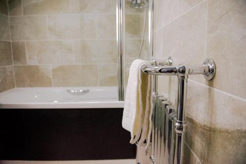 a bathroom with a shower and a sink and a towel at The Black Boy Inn in Caernarfon