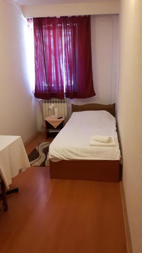 a bedroom with a bed and a red window at RESTORAN PRENOĆIŠTE CROATIA TURIST in Ðakovo