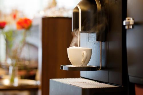 a coffee cup sitting on top of a coffee machine at Stern am Rathaus in Cologne