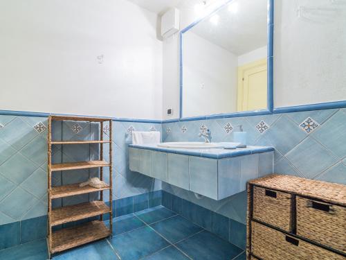 カルロフォルテにあるCasa Taccarossaの青いバスルーム(シンク、鏡付)