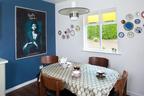 a dining room with a table and a poster of a woman at The Dolls House in Wexford