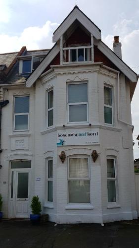 a white house with a sign on the front of it at Boscombe Reef Hotel in Bournemouth