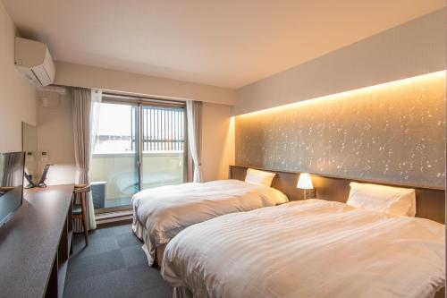 um quarto de hotel com duas camas e uma janela em Karasuma Rokujo Hotel em Quioto