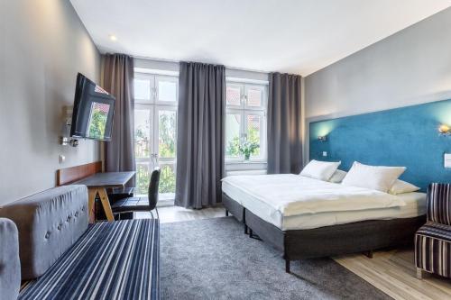 Pokój hotelowy z łóżkiem i biurkiem w obiekcie Hotel Kaliski w Słubicach