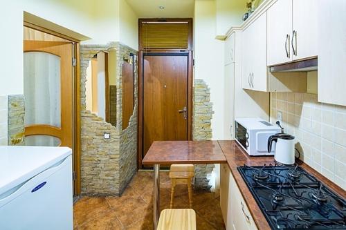 cocina con encimera y microondas en Apartment Zhyzhky 9, en Leópolis