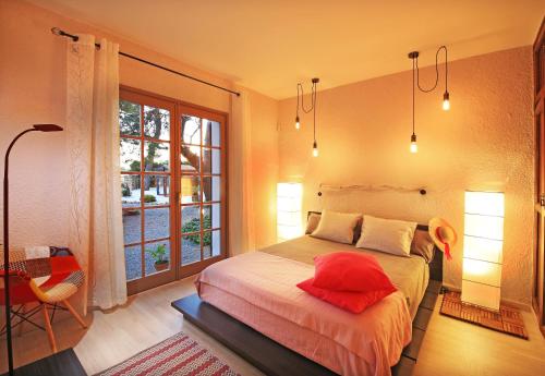 Un dormitorio con una cama con una almohada roja. en Casa Rural Els Pins, en Sant Marçal