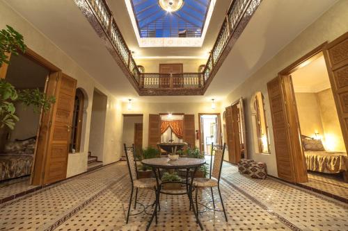 ein Esszimmer mit einem Tisch, Stühlen und einem Dachfenster in der Unterkunft Riad Dar Saidi in Rabat