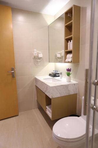 a bathroom with a sink and a toilet and a mirror at Yumi Apartment Lida Plaza Branch in Guangzhou