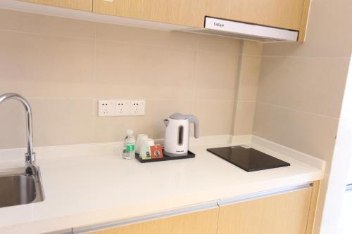 a kitchen counter with a coffee maker on it at Yumi Apartment Lida Plaza Branch in Guangzhou