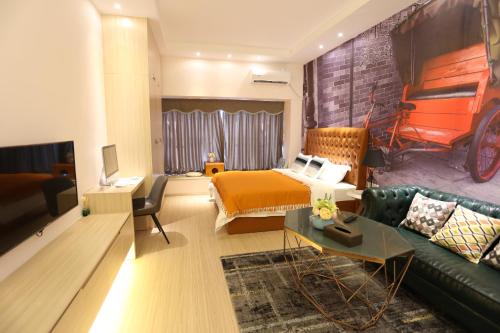 a living room with a bed and a couch at Yumi Apartment Lida Plaza Branch in Guangzhou