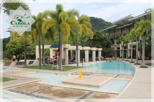 a swimming pool with palm trees in front of a building at CAROLA in Pico de Loro in Nasugbu