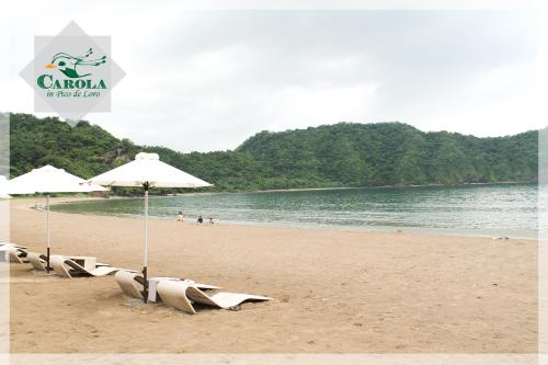 a group of beach chairs and umbrellas on a beach at CAROLA in Pico de Loro in Nasugbu