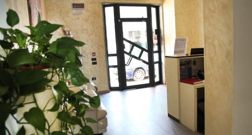 a room with an open door with a plant in front at Hotel Sogni D'Oro Airport in Lamezia Terme