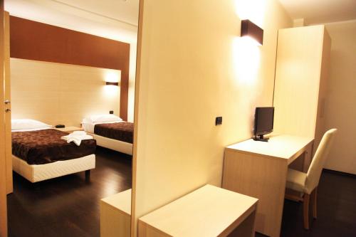 a hotel room with two beds and a mirror at Hotel Sogni D'Oro Airport in Lamezia Terme