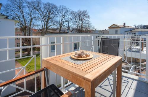 a balcony with a wooden table on a deck at Aparthotel Villa Lea in Ahlbeck