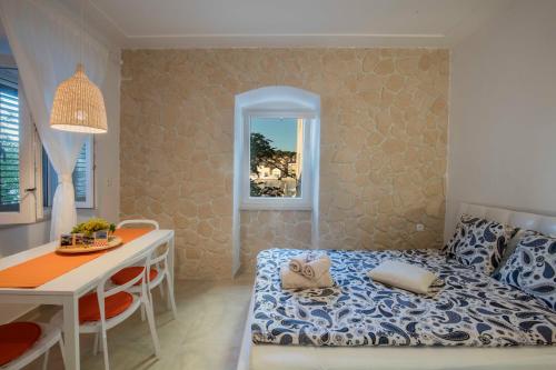 a bedroom with a bed and a desk and a table at Season4All Apartments in Mali Lošinj