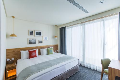 um quarto de hotel com uma cama grande e uma janela em Sun Dialogue Hotel-By Cosmos Creation em Chiayi City