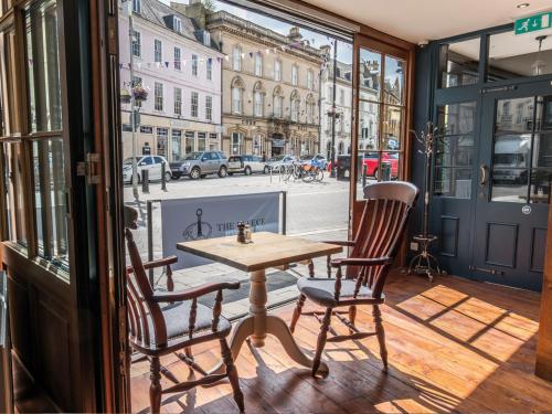 a table and two chairs on a balcony with a street at The Fleece at Cirencester in Cirencester